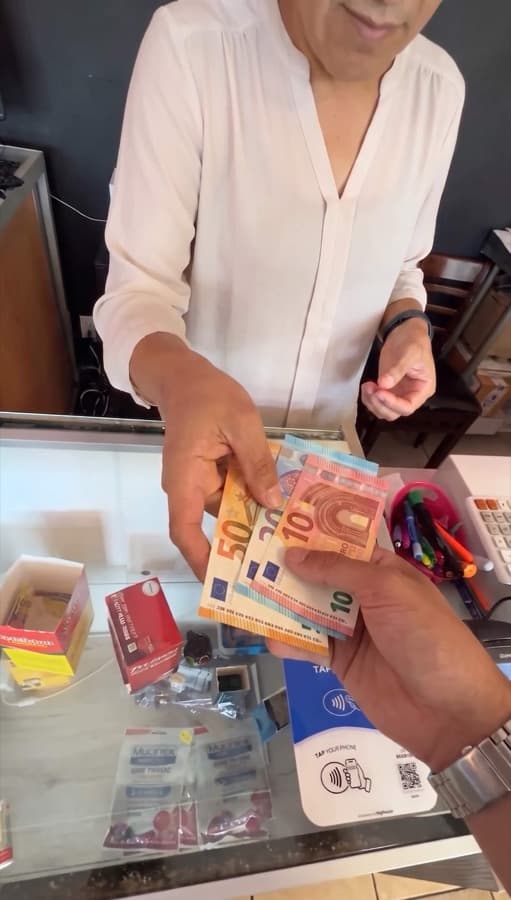 A Google review card on a shop counter, tapped with a phone (4)